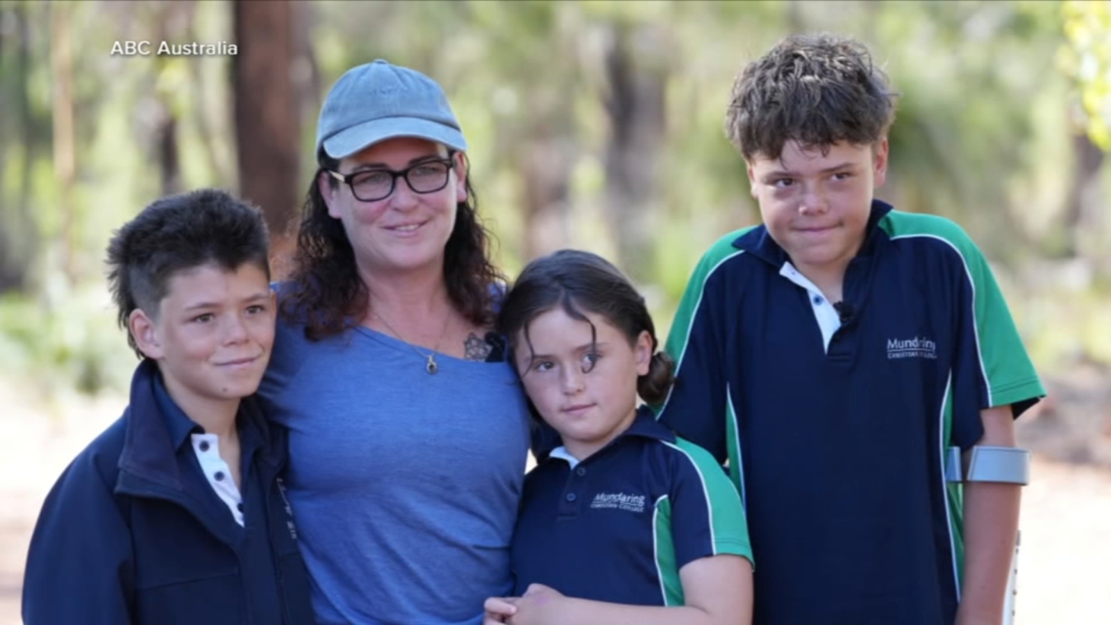 A young boy swimming alone in rough ocean waters as the coastline appears faint in the distance.