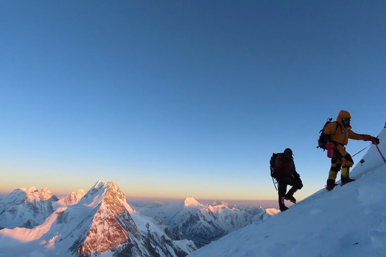 A climber crossing a fractured Himalayan glacier under shifting ice towers affected by rising temperatures.
