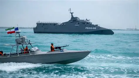 Military vessel and patrol boat navigating at sea during maritime operations.