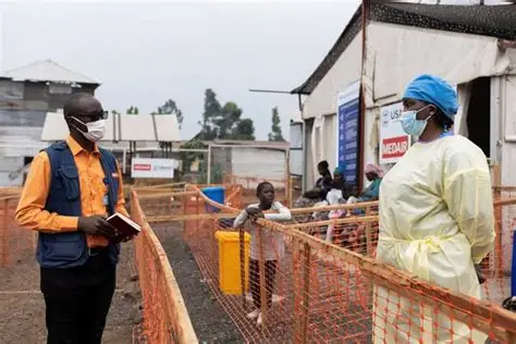 Health workers in protective gear manage an Ebola screening area as humanitarian teams respond to the Bundibugyo outbreak in Central Africa.