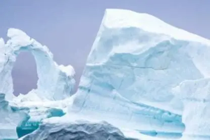 Antarctica Ice Sheet Collapse – eroded iceberg arch over turquoise polar waters