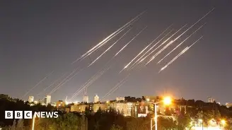 us iran tensions rocket trails over a nighttime city during an aerial attack
