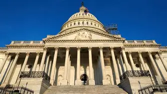 Low‑angle view of the United States Capitol dome against a clear blue sky, highlighting its neoclassical architecture