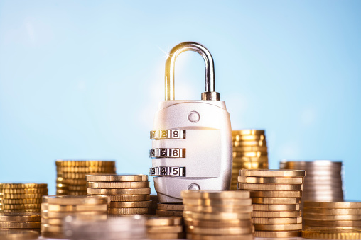 Financial Security in 2026 – Protecting Wealth in an Uncertain Economy Financial security in 2026 represented by a combination lock placed among stacks of gold coins, symbolizing protected savings and economic resilience.