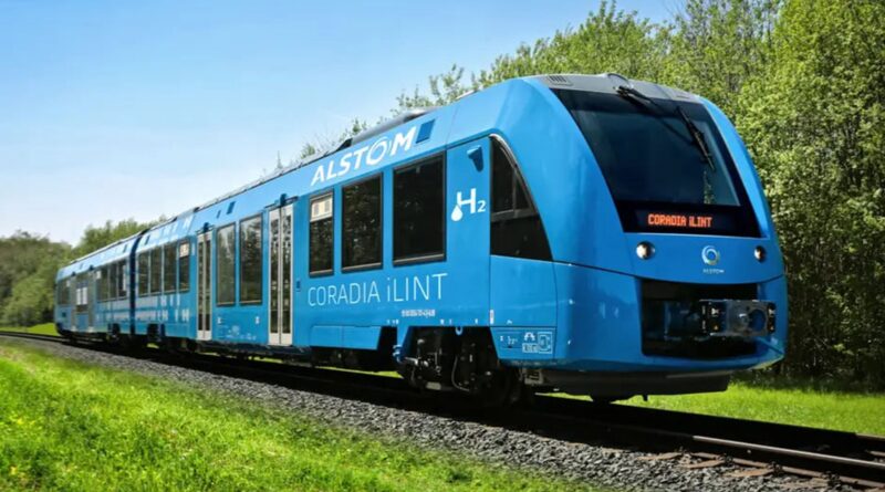 Alstom Coradia iLint, the hydrogen‑powered passenger train in service, running on a regional line through green fields with its blue livery and H₂ marking.